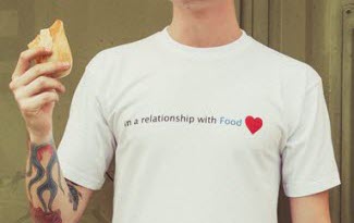 Jednoduché bílé tričko s potiskem In a relationship with food. Modrý text food a červené srdíčko na konci věty.